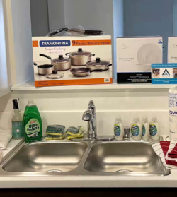 Kitchen sink with household supplies and cookware