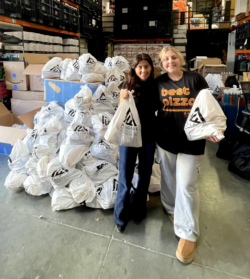 Two volunteers holding bags of supplies