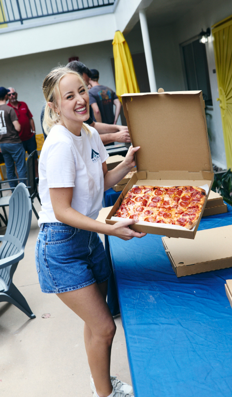 Woman holding a pizza at The Shores Volunteer Day