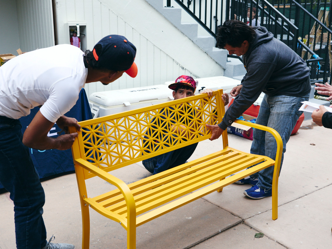 Photograph of three people installing a bench