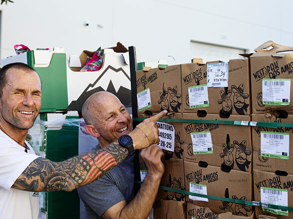 Volunteers pointing at boxes of produce
