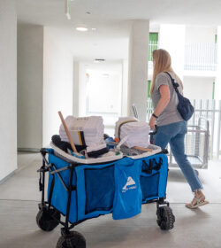 A volunteer with a cart of cleaning supplies