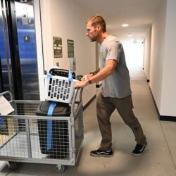 A man at cuatro city heights pushing a card of supplies
