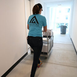 A woman in an Allgire Foundation t-shirt pushing a cart of supplies